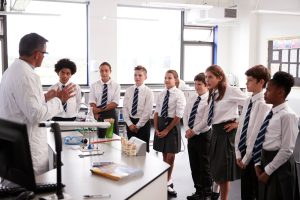 Male,High,School,Tutor,Teaching,High,School,Students,Wearing,Uniforms