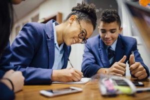 Teen,Students,Are,Working,Together,And,Taking,Notes,In,Lesson